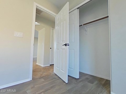 a bedroom with two closets and a door into a hallway