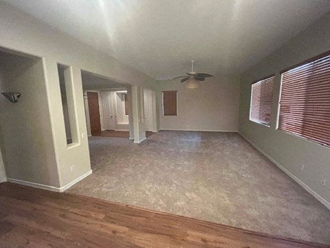 an empty living room with a ceiling fan
