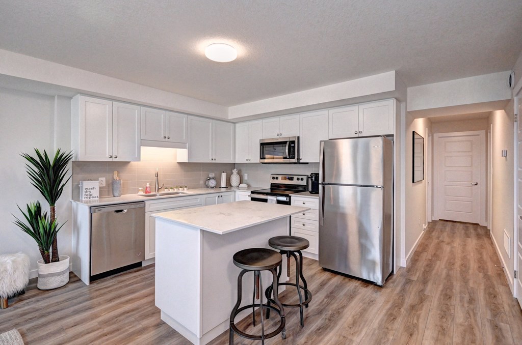 a kitchen with white cabinets and stainless steel appliances