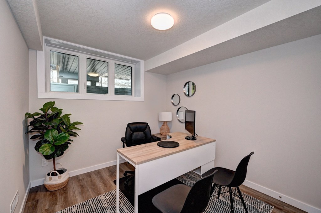 a home office with a desk and a window