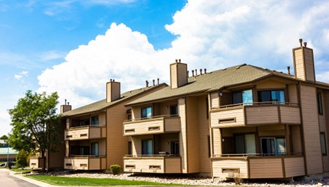 a large apartment building with a cloudy sky in the background