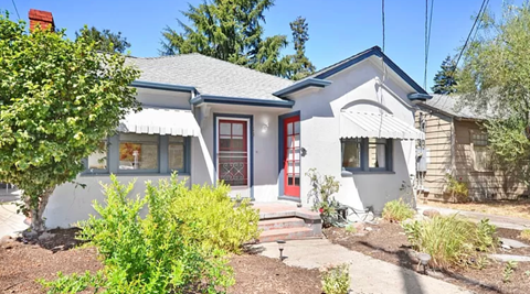 a white house with a red door and a sidewalk