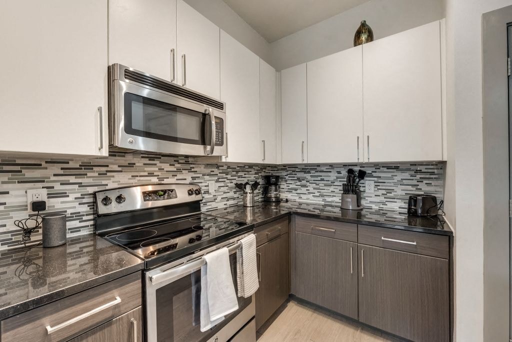a kitchen with stainless steel appliances and white cabinets