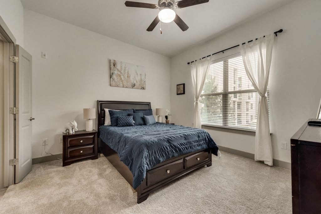 a bedroom with a bed and a ceiling fan