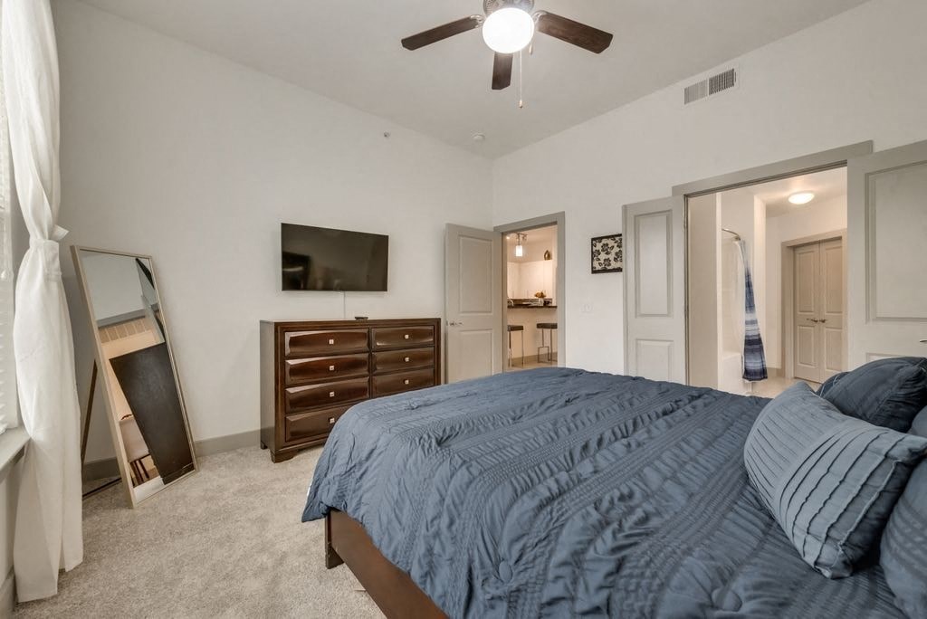 a bedroom with a bed and a ceiling fan