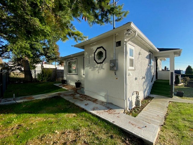 a small gray house with a porch and a tree