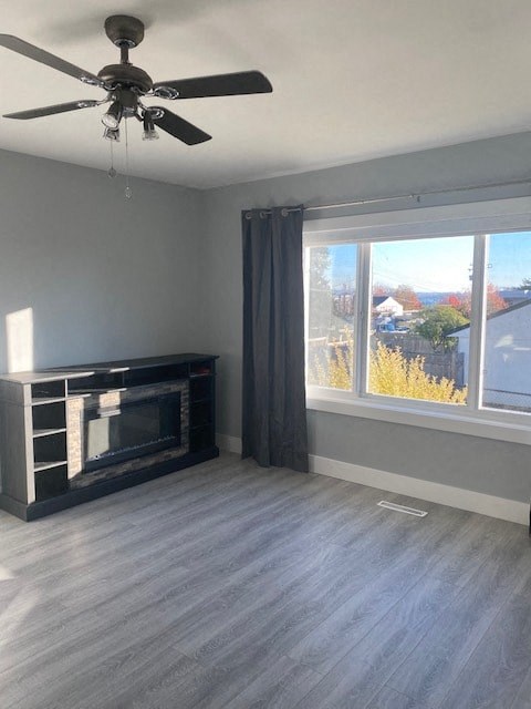 a living room with a fireplace and a ceiling fan