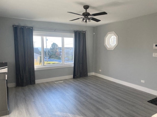 an empty living room with a ceiling fan and a window
