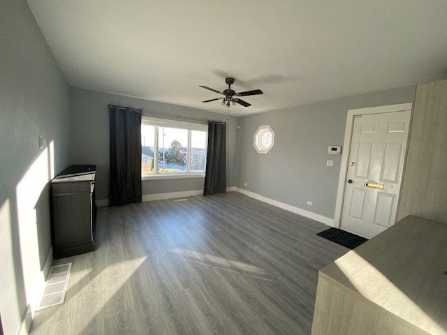 an empty living room with a ceiling fan and a window