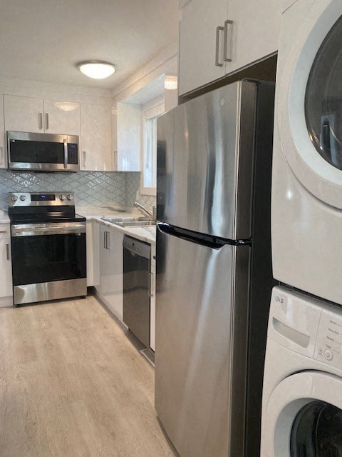 a kitchen with a washing machine and a stainless steel refrigerator