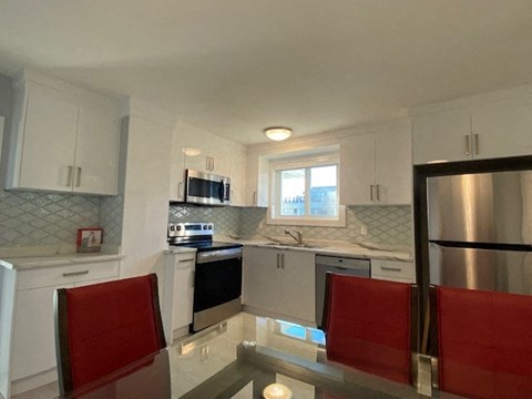 a kitchen with white cabinets and a table and chairs