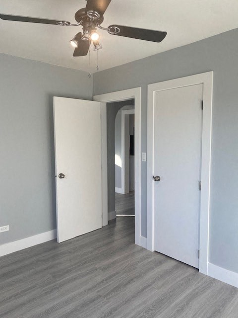 an empty room with two doors and a ceiling fan