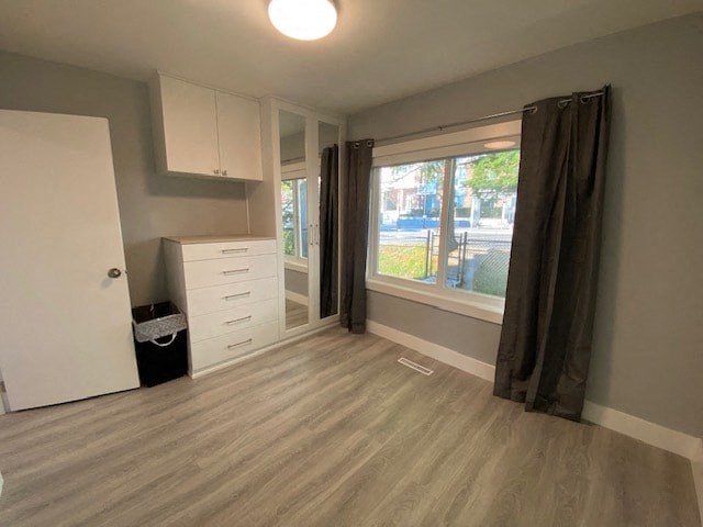 an empty room with a window and a white cabinet