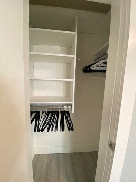 a closet with white shelves and a closet door