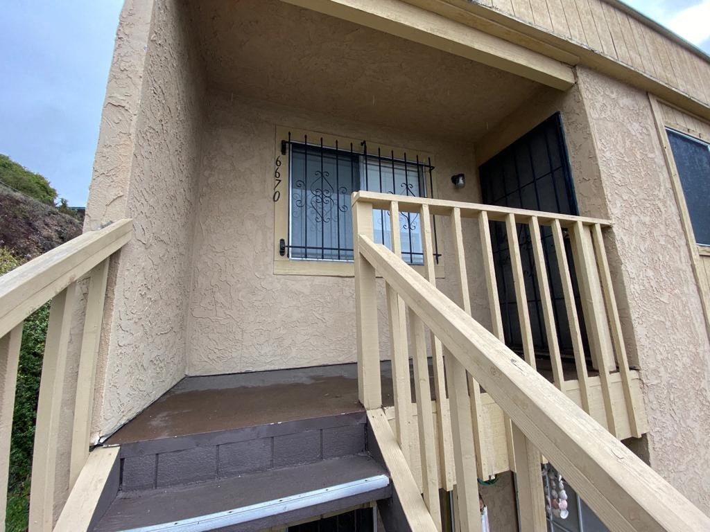 a porch of a building with a staircase and a window