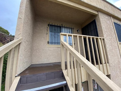 a porch of a building with a staircase and a window
