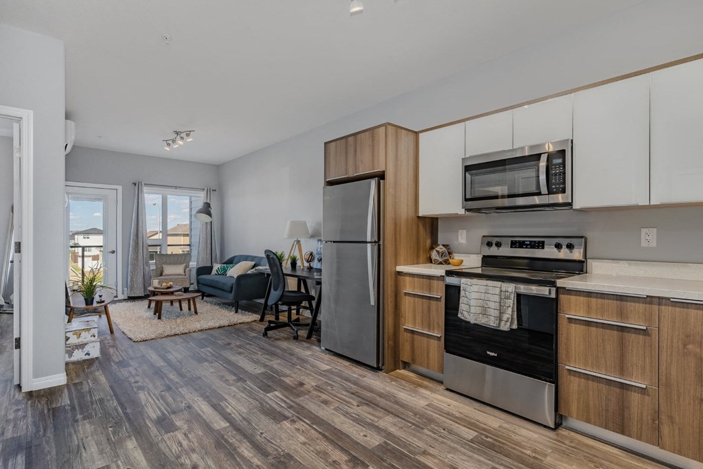 A modern kitchen with a refrigerator, oven, and microwave.