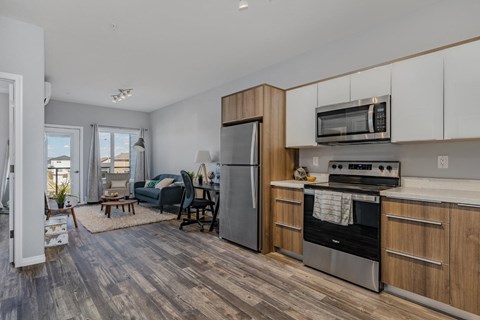 A modern kitchen with a refrigerator, oven, and microwave.