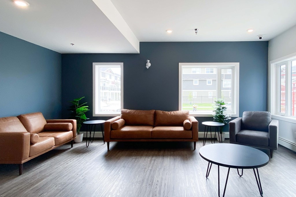 A living room with brown leather furniture and a grey armchair.
