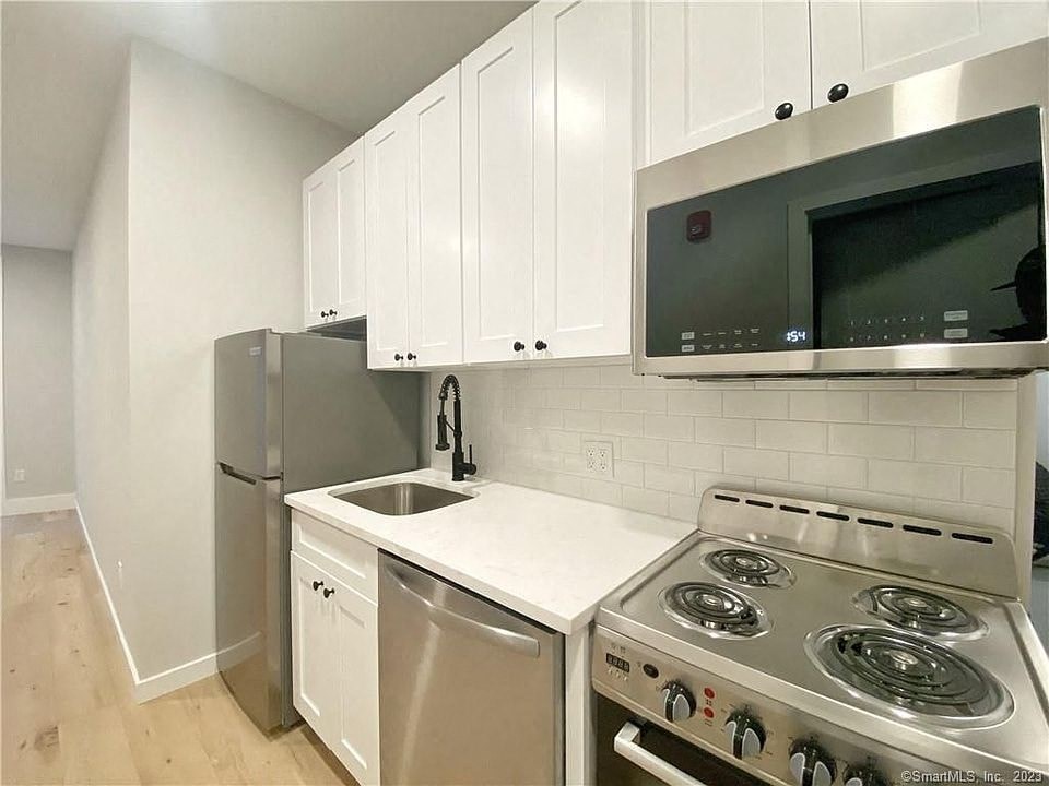 a kitchen with a stove and a sink and a refrigerator