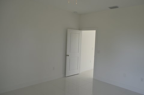 an empty room with a door and a white wall