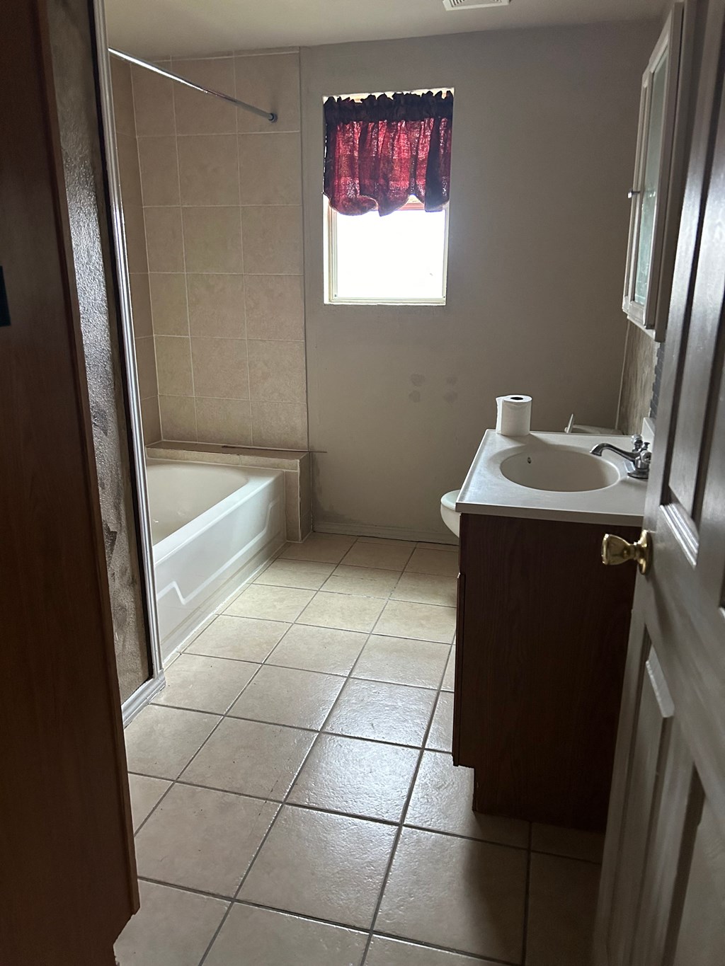 a bathroom with a sink and a tub and a window