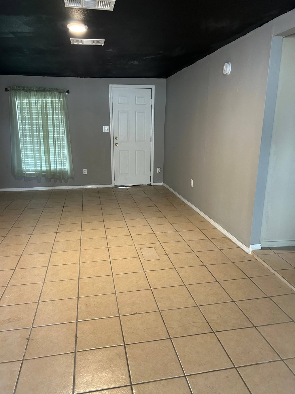 an empty room with a tiled floor and a white door