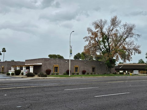 a brick building with yellow doors on the side of a road