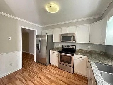 a kitchen with stainless steel appliances and a wooden floor