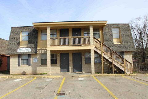 the front of an apartment building with stairs and a balcony
