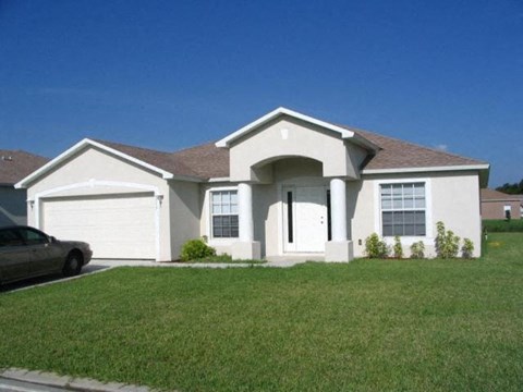 A house with a car parked in front.