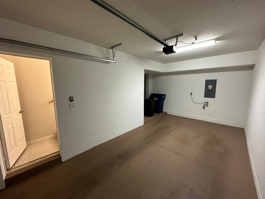 the living room is empty and the door is open to the garage