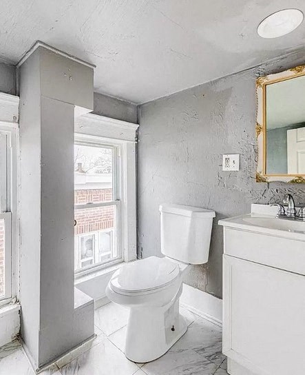 a bathroom with a toilet and a sink and a window