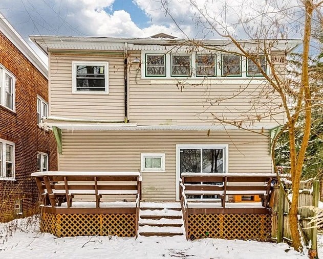 a house with a wooden deck in the snow