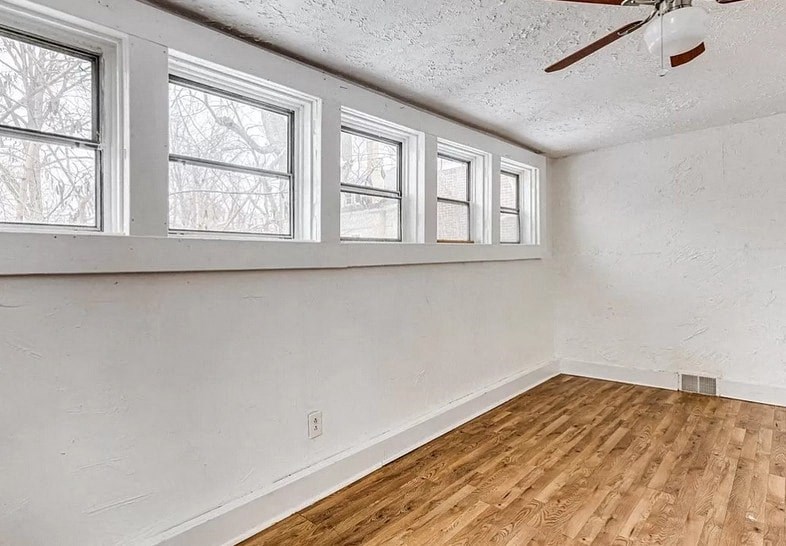 an empty room with a hardwood floor and a window