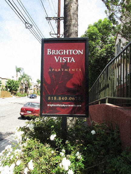 a sign for the apartments on the side of the street