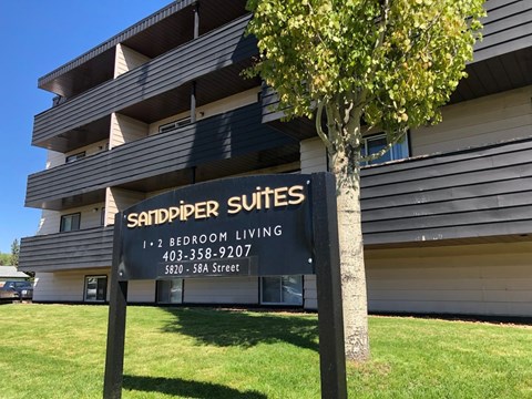 A sign for Sandpiper Suites is shown in front of a building.