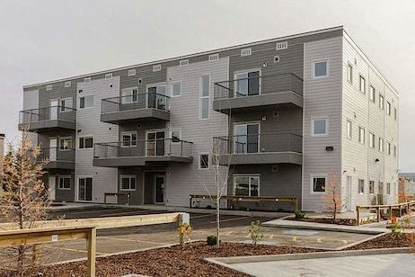 Apartment building with balconies and doors.
