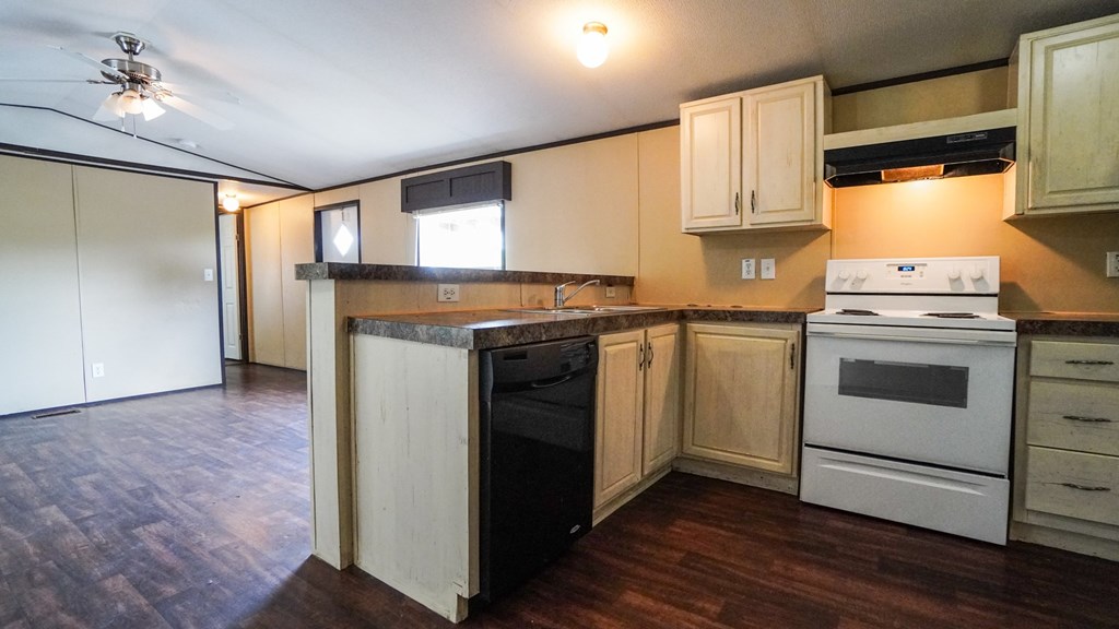 A kitchen with a white oven and wooden cabinets.