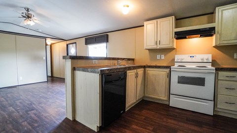 A kitchen with a white oven and wooden cabinets.