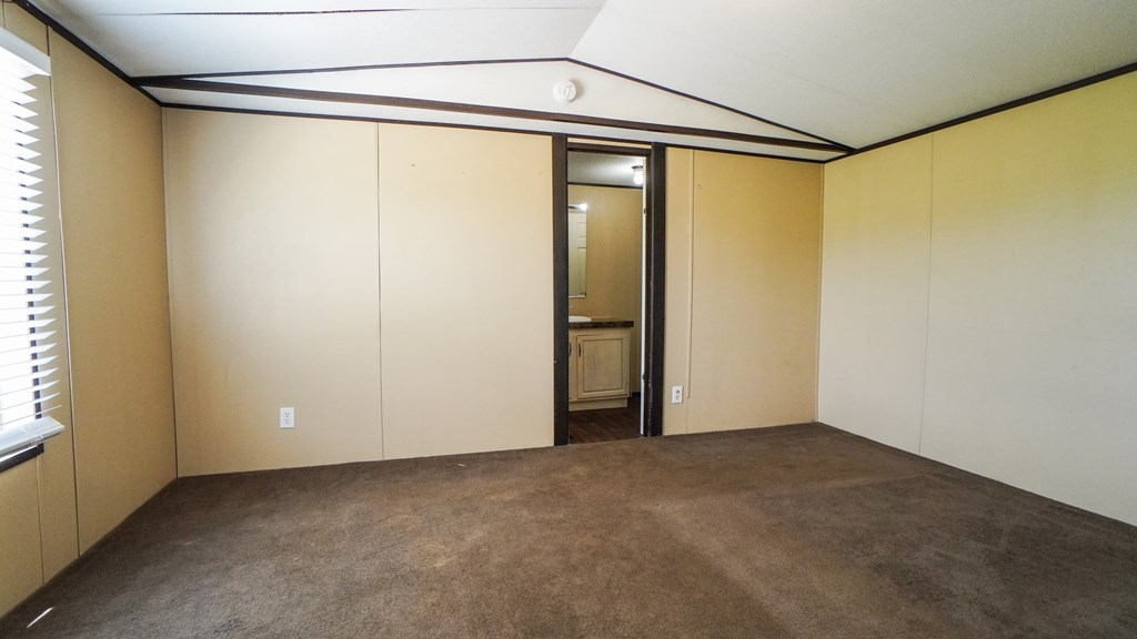A room with a brown carpet and a brown door.
