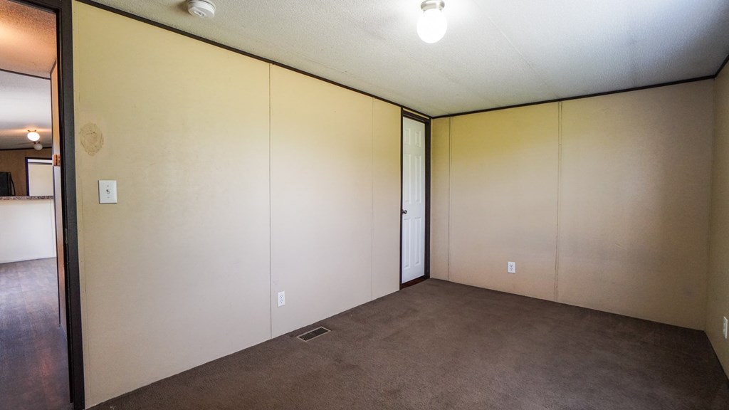 A room with beige walls and carpet.