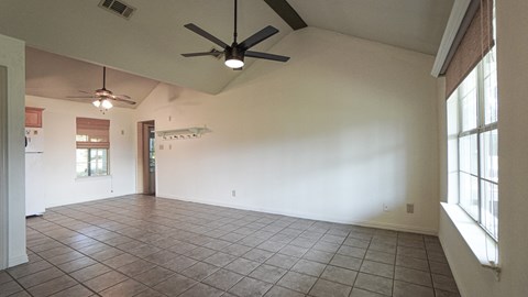 A room with a ceiling fan and tile flooring.