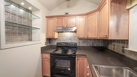 A kitchen with wooden cabinets and a black stove top oven.