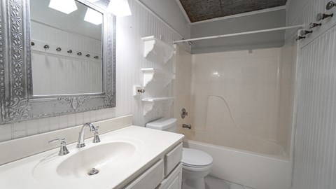 A white bathroom with a sink, toilet, and bathtub.