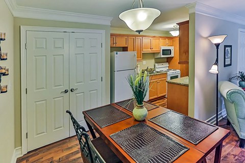 A kitchen with a table and chairs in the foreground.