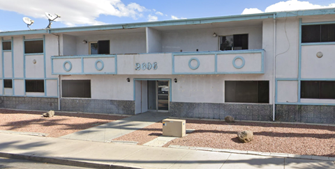 an old building with a blue and white facade and a sidewalk