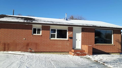 a brick house with a snow covered roof