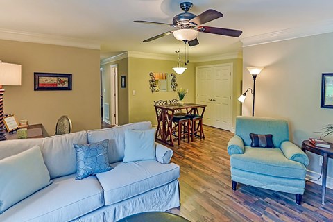 A living room with a white couch and a blue chair.