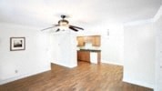 an empty living room with a ceiling fan